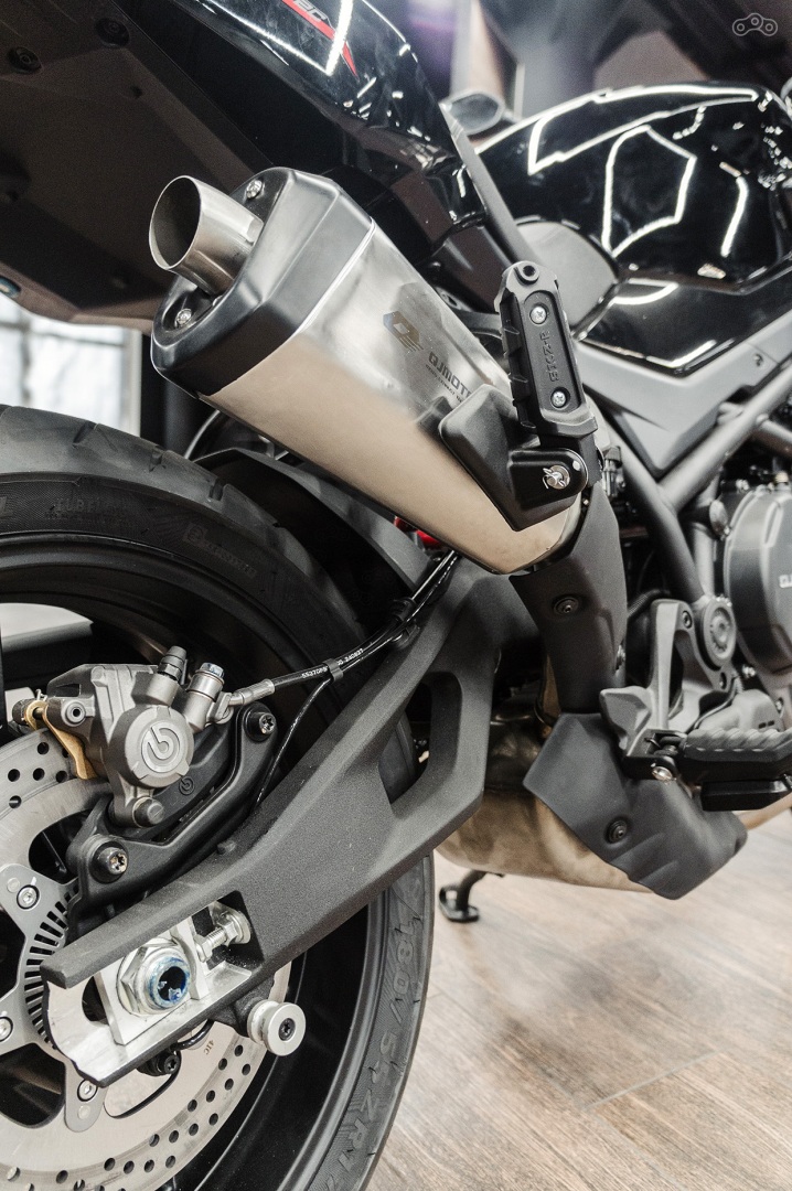 Эту статью может увидеть больше людей Настройте продвижение для привлечения внимания к публикации и роста числа подписчиков Настроить продвижение QJMOTOR ваш канал Перейти в Студию QJMOTOR SRK 900. Мягкая сила 25 марта 300 5 мин Это самобытно и красиво. Вздыбленный, словно приготовившийся к прыжку, силуэт, вертикальная фара с двумя полосками ходовых огней и раздвоенные задние фонари вместе с проглядывающей из-под боковин ребрами рамы типа «птичья клетка». Остальные аргументы тоже весомы: 904-кубовый «рядник», регулируемые подвески и полный набор водительской электроники. Казалось бы, всё то же самое найдётся и у других. Однако то, как все его части собраны воедино, делает QJMOTOR SRK 900 уникальным. Крутой внешний вид и динамика — его главные составляющие Мы с коллегами безмолвно разглядываем одну из главных премьер этого года — и насмотреться не можем. Невзирая на нестандартный, местами даже вычурный дизайн, его внешность парадоксально хороша! И вроде новый QJMOTOR SRK 900 с заводским индексом QJ900-2C пока не трогаем, но он уже делится своим настроением. Аж мурашки по коже... Притягателен. Массивен. Груб. Настоящий мужик. Или, если поддаться транслируемому через дизайн настроению, нахмурившийся зверь, которого предстоит приручить. Фара и задний фонарь, конечно же, светодиодные. Их несомненное преимущество — идеальное освещение при любой видимости Однако внешность — хоть и не последний фактор в выборе, но далеко не самый важный. Многие (скажем прямо, и мы тоже) принимают окончательное решение, лишь после обязательного диалога с внутренним вечным спорщиком и критиком, который в большинстве случаев прав, но до чего же занудлив. Чтобы после многочасовых обсуждений с этим альтернативным «я» и обязательного взвешивания разных аргументов за и против наконец прочувствовать тот самый «секретный ингредиент», превращающий просто хороший мотоцикл, коих на свете достаточно, в тот самый. Посадка за рулём SRK 900 с едва заметным наклоном вперёд полностью соответствует городскому предназначению. Водительское сиденье размещено на высоте 810 мм от земли, что при учёте его небольшой ширины позволяет устроиться с комфортом людям самого разного роста У SRK900 с ингредиентами всё в порядке. Взять, к примеру, новую рядную «двойку» серии QJ292MX-A. В её слегка приглушённом, но глубоком баритоне отчетливо слышны знакомые нотки ритмичных вспышек в цилиндрах — тот звук, что у нас песнью зовется. Он заставляет улыбаться, чувствовать вкус к жизни и хорошим мотоциклам. И нет, не громко: заводской выпуск создает красивую акустическую картину во всем диапазоне оборотов, но не нарушает рамки приличий. Голос мотора SRK 900 — тот звук, что у нас песнью зовется