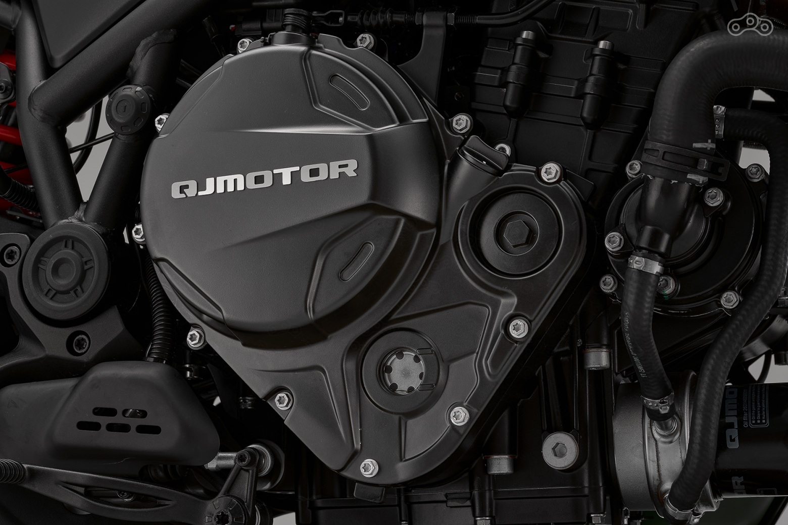 Не купи Qianjiang Group в 2005 году итальянскую Benelli, данного силового агрегата у QJMOTOR наверняка не было бы. В своей прошлой жизни он, с подачи бывшего двигателиста Ferrari и Cagiva Риккардо Росы, был трёхцилиндровым и приводил в движение экстраординарные Benelli Tornado Tre 900 и TNT 1130. Спустя 15 лет от мотора отрезали один цилиндр и установили в недра нейкеда Benelli 752 S. И вот теперь рядная «двойка» по родственной линии досталась QJMOTOR SRK 900. Не без изменений, само собой. Рабочий объём двигателя вырос до 904 см³ (88×68 мм), что вкупе с увеличившейся до 12,2:1 степенью сжатия помогло поднять мощность до 95,2 л.с. при 9000 об/мин, а крутящий момент — до 90 Н·м при 6500 об/мин. При этом 80% тяги приходится на диапазон от 3500 до 9000 об/мин.